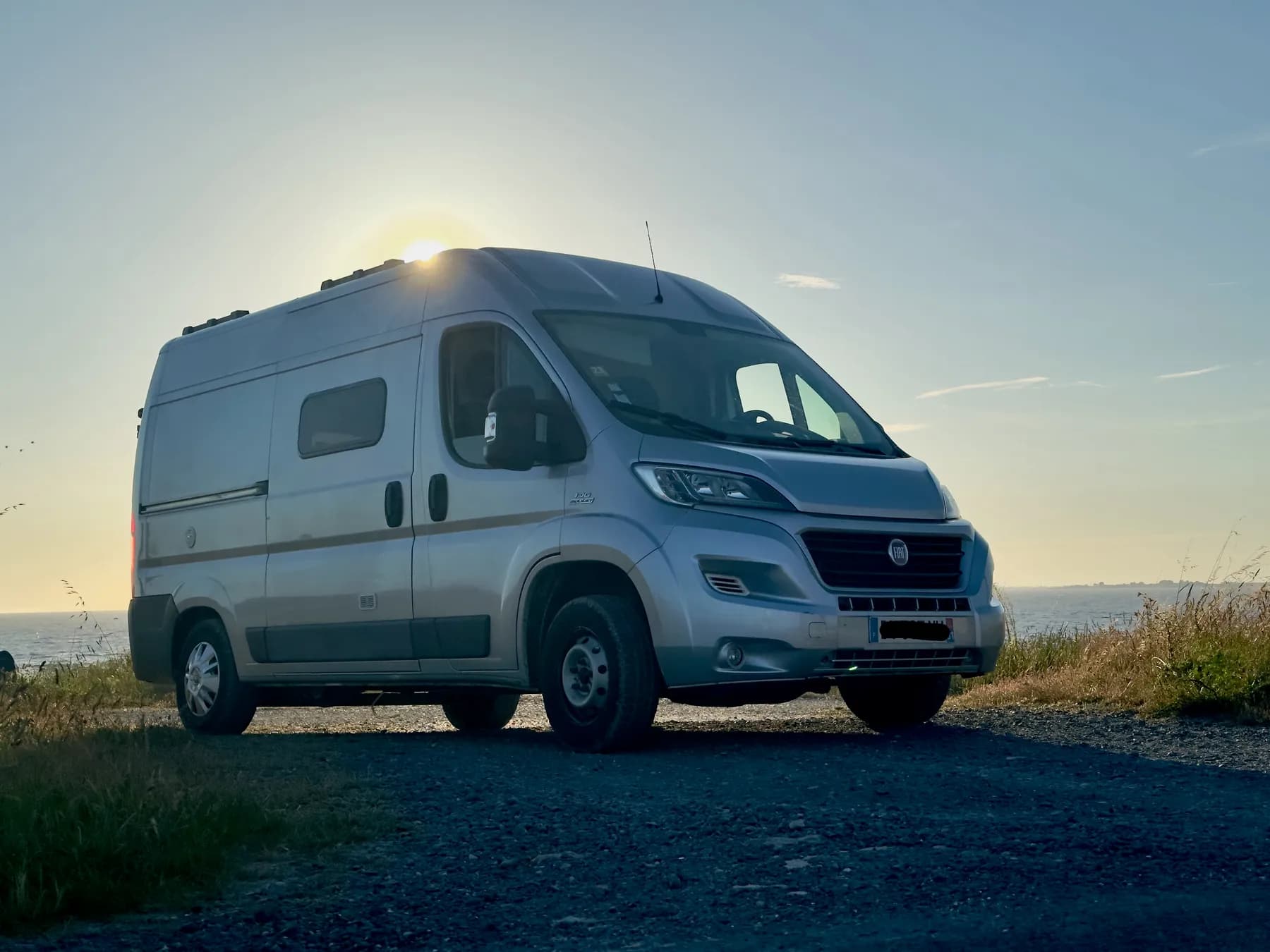 Léonard, un Fiat Ducato aménagé par Le Van Trotter, garé face à la mer au lever du soleil