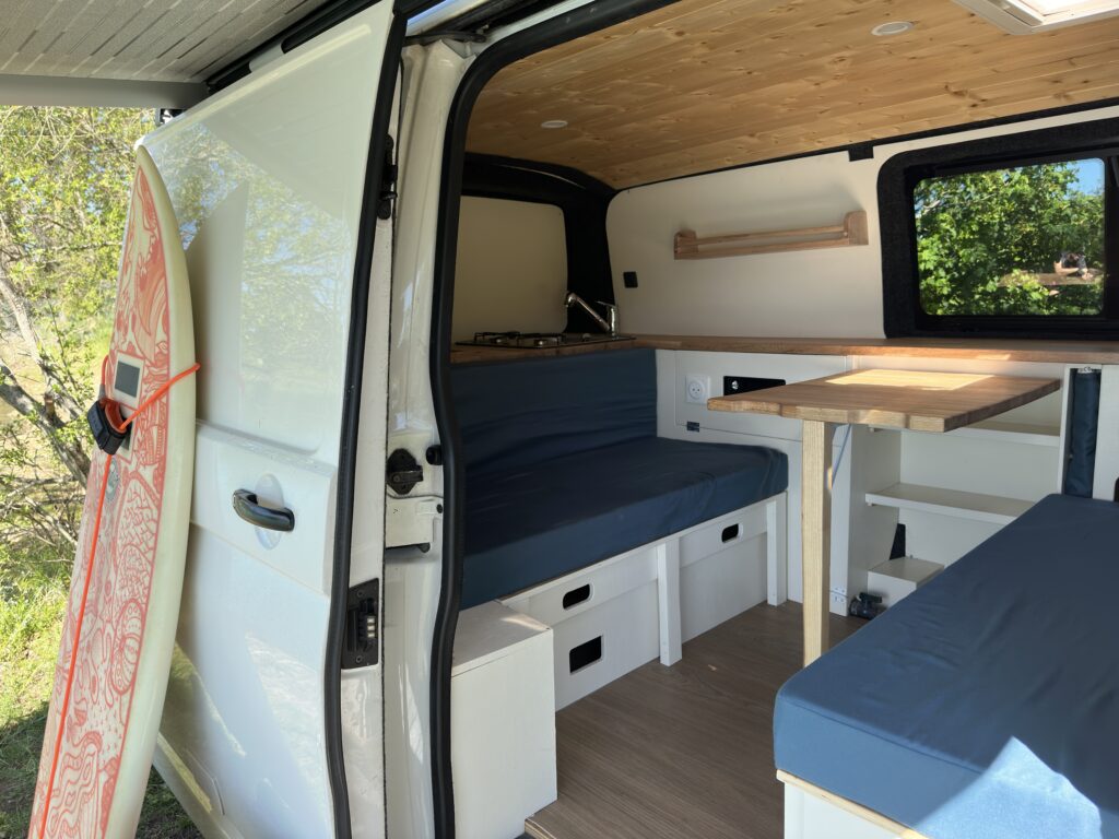L'intérieur d'un van avec une planche de surf contre le van à l'extérieur